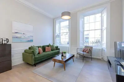 a living room with a green couch and a table at Dragon Suites - Edinburgh City Centre 1 Bed Apartment in Edinburgh
