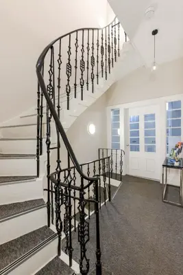 a spiral staircase in a home with white walls at Dragon Suites - Edinburgh City Centre 1 Bed Apartment in Edinburgh