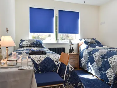 a bedroom with two beds and a window with blue blinds at 4 Dolphins in Connel