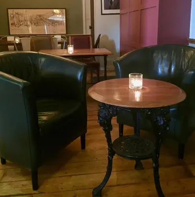 a table and two chairs and a table with a glass on it at Black Bull Gartmore in Stirling