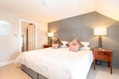 a bedroom with a large white bed with pink pillows at Black Bull Gartmore in Stirling