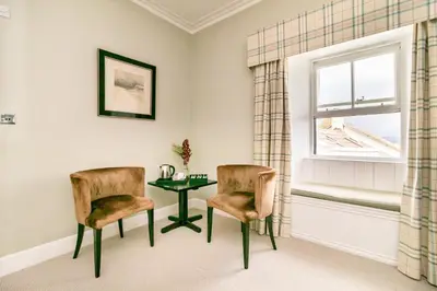 a room with two chairs and a table and a window at Black Bull Gartmore in Stirling