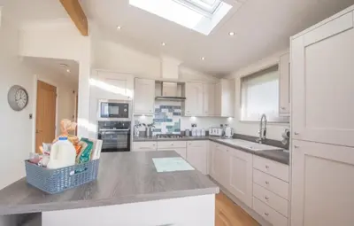 a kitchen with a baby in a basket on a counter at 2 Bedroom Sleeps 4 Lodge-Smart Tv-Hot tub-Dogs Ok in Lochwinnoch