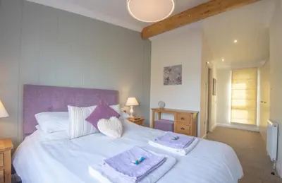 a bedroom with a white bed with towels on it at 2 Bedroom Sleeps 4 Lodge-Smart Tv-Hot tub-Dogs Ok in Lochwinnoch
