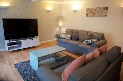 a living room with two couches and a flat screen tv at No 2 Planetree in Lochgoilhead