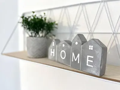 a shelf with a home sign and a potted plant at Kingsbridge Apartment in Glasgow