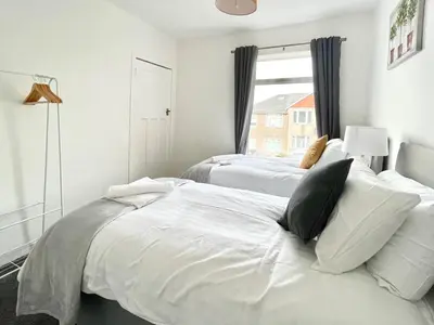 a bedroom with two beds and a window at Kingsbridge Apartment in Glasgow