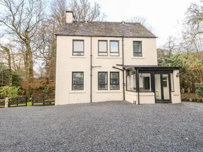 a white house with a driveway in front of it at Burnside House in Dalmally
