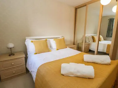 a bedroom with a large bed with two towels on it at Burnside House in Dalmally