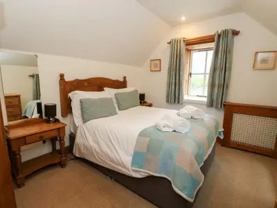 a bedroom with a bed with towels on it at The Steading in Dalmally