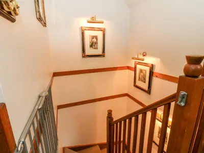 a staircase with two framed pictures on the wall at The Steading in Dalmally