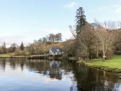 a house on the bank of a river at The Steading in Dalmally