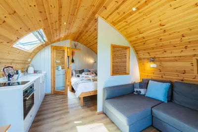 a living room with a couch and a bedroom at The Stag Pod Farm Stay with Hot Tub Sleeps 2 in Galston