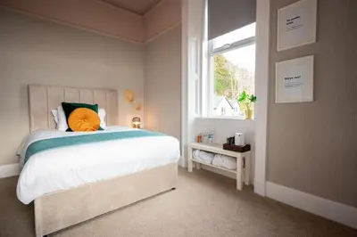 a bedroom with a large bed and a window at Witchwood House in Oban