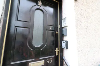 a black door with a round window on it at Macintosh Upper in Bellshill