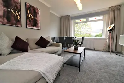 a bedroom with a bed and a couch and a table at Macintosh lower in Bellshill