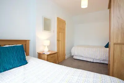 a bedroom with two beds and a lamp on a table at Avonlea Self-Catering in Crieff