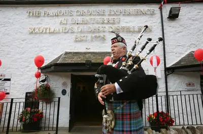 a man in a kilt playing a bagpipe in front of a building at Avonlea Self-Catering in Crieff