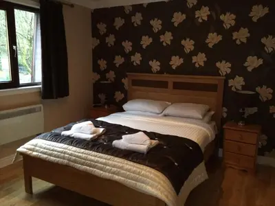 a bedroom with a bed with two towels on it at Ben Arthur's Bothy Luxury Flat in Arrochar