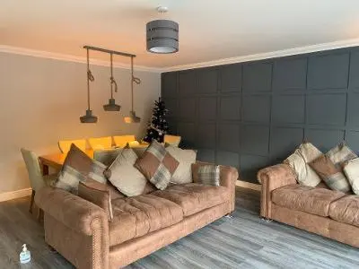 a living room with two couches and a christmas tree at Ben Arthur's Bothy Luxury Flat in Arrochar