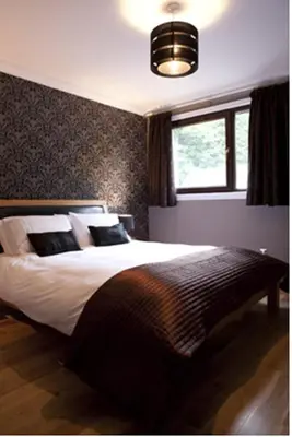 a bedroom with a large bed and a window at Ben Arthur's Bothy Luxury Flat in Arrochar
