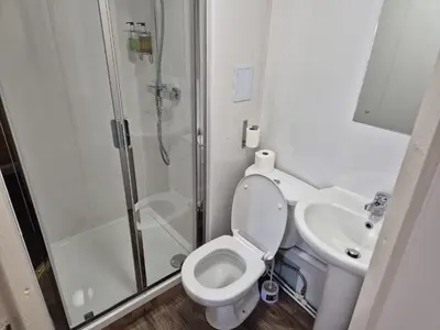 a bathroom with a shower and a toilet and a sink at Glasgow House in Glasgow