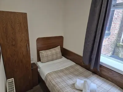 a small bedroom with a bed and a window at Glasgow House in Glasgow
