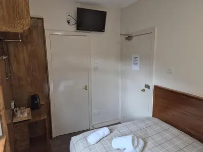 a bedroom with a bed and a tv on the wall at Glasgow House in Glasgow