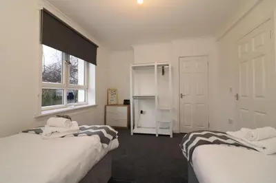 a bedroom with two beds and a window at Signature - Carrick View in Cumbernauld