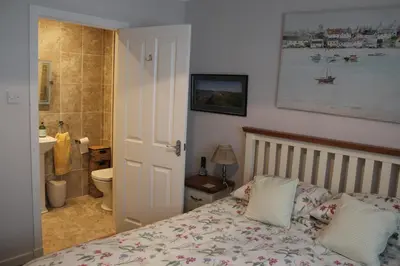 a bedroom with a bed and a bathroom at Osborne Cottage in Southend