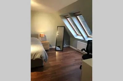 a bedroom with a bed and a mirror at Struan Coach house in gated residence in Stirling