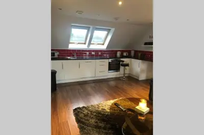a kitchen with white cabinets and a table in a room at Struan Coach house in gated residence in Stirling