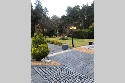 a garden with a brick walkway and bushes at Struan Coach house in gated residence in Stirling