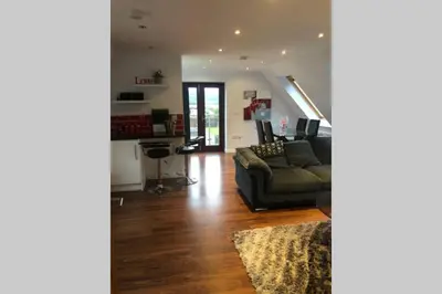 a living room with a couch and a table at Struan Coach house in gated residence in Stirling