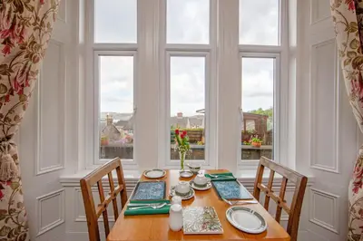 a dining room with a table and two chairs and a window at Hawthornbank in Oban