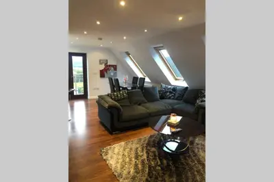 a living room with a couch and a table at Private Coach house in gated residence in Stirling
