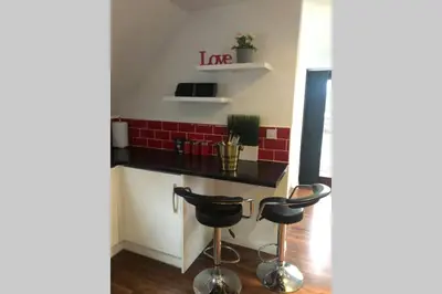 a kitchen with a black counter and two stools at Private Coach house in gated residence in Stirling