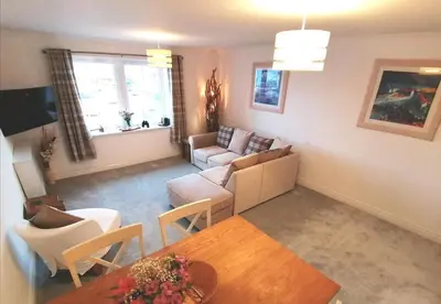 a living room with a couch and a table at Seaside Apartment in Oban