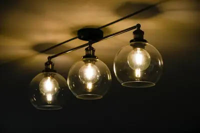 a group of four glass lights hanging from a ceiling at The Gallery Apartment - Spacious, Town Centre, Walkable to Ferry Terminal, in Oban