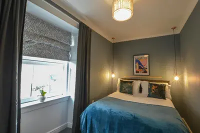 a small bedroom with a bed and a window at The Gallery Apartment - Spacious, Town Centre, Walkable to Ferry Terminal, in Oban