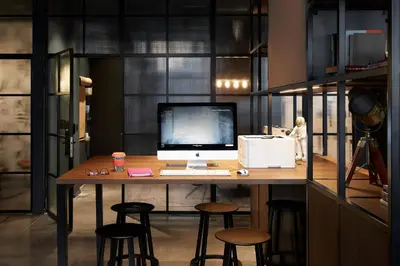 an office with a desk with a computer and stools at Moxy Edinburgh Fountainbridge in Edinburgh