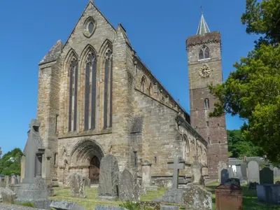 an old stone church with a clock tower at Maisie's Cottage in Dunblane