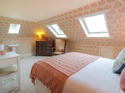 a bedroom with a bed and two skylights at Maisie's Cottage in Dunblane
