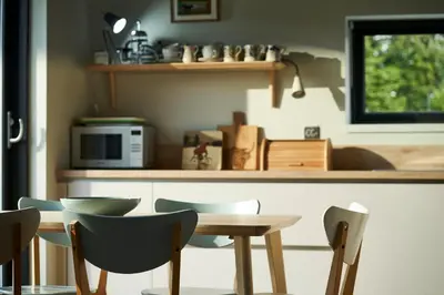 a kitchen with a table and chairs and a microwave at An Airigh in Cairndow