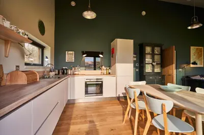 a large kitchen with a table and chairs at An Airigh in Cairndow