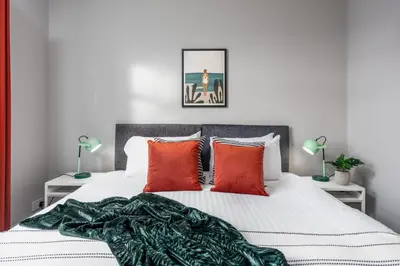 a bedroom with a white bed with red pillows at Sunset View - Donnini Apartments in Ayr