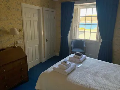 a bedroom with a bed with towels and a window at The Manor House in Oban
