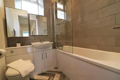 a bathroom with a sink and a tub and a toilet at Signature - Railway Cottage in Maryhill