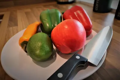 a plate of vegetables with a knife on a table at Signature - Railway Cottage in Maryhill