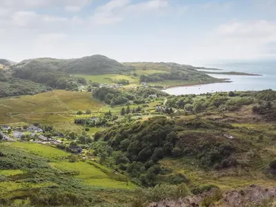 an aerial view of a village on a hill with the ocean at Ar Deireadh in Tayvallich